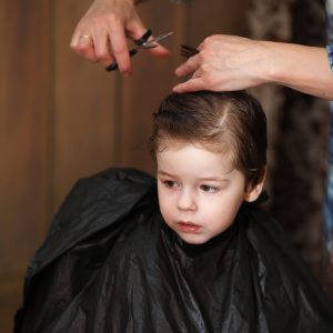 A little boy is trimmed in the hairdresser's bright emotions on his face